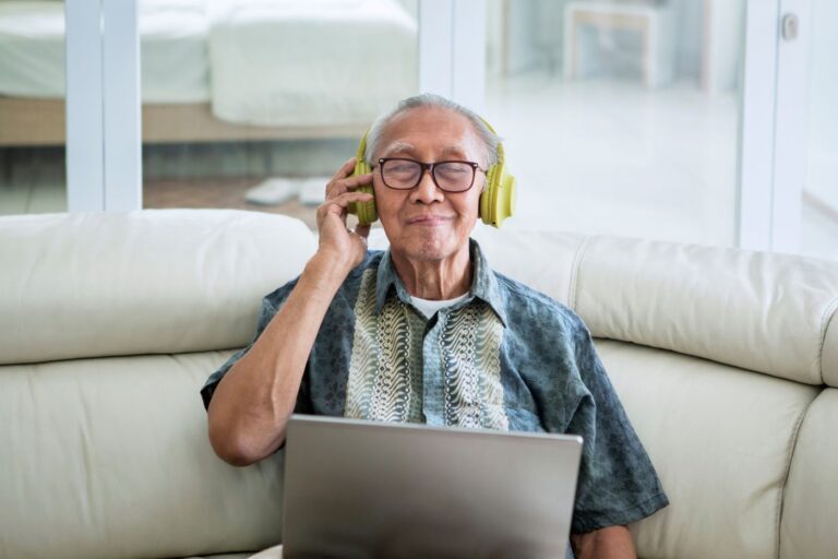 pensjonist bruker datamaskin og lytter på avlesning av tekst
